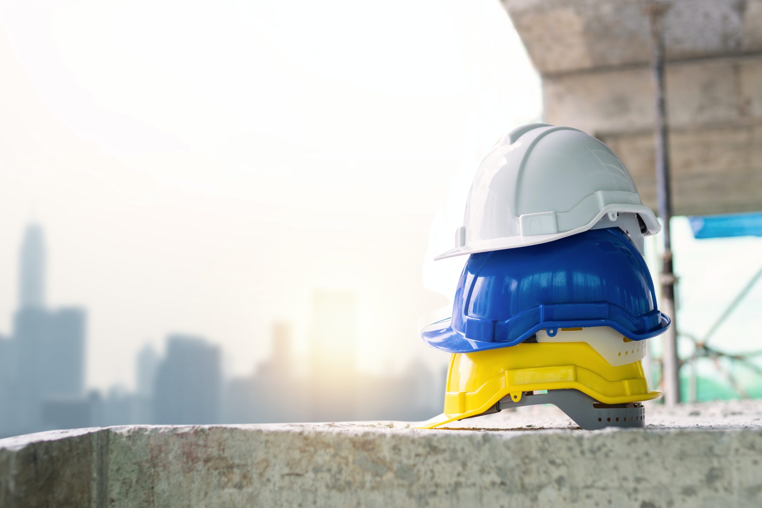 Three hard hats stacked on a ledge